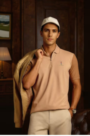 Man in beige polo shirt and white cap holding a jacket over his shoulder, standing indoors near a lamp and framed artwork.