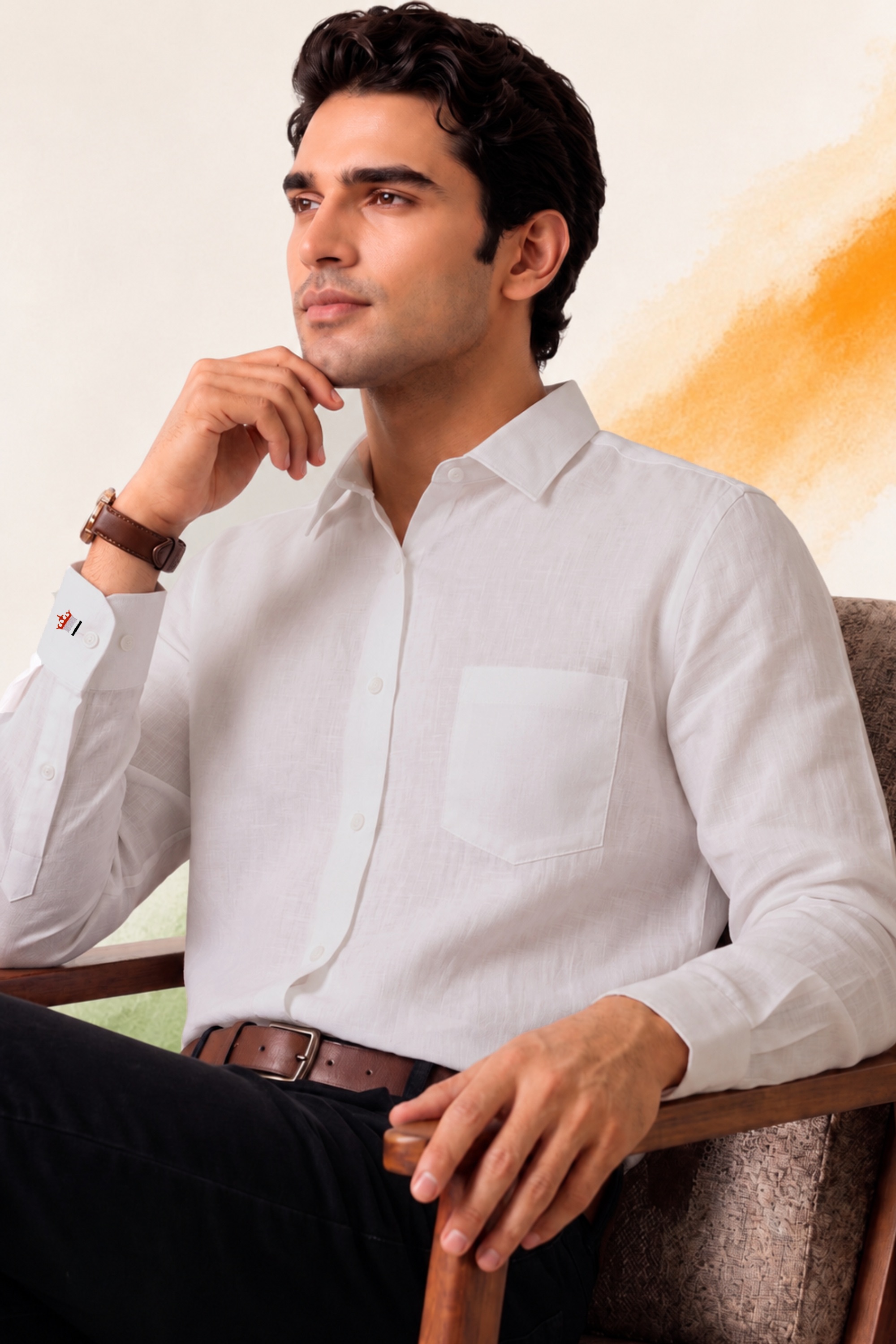 Young man in a white shirt sitting thoughtfully on a chair against a light background with an orange brushstroke.