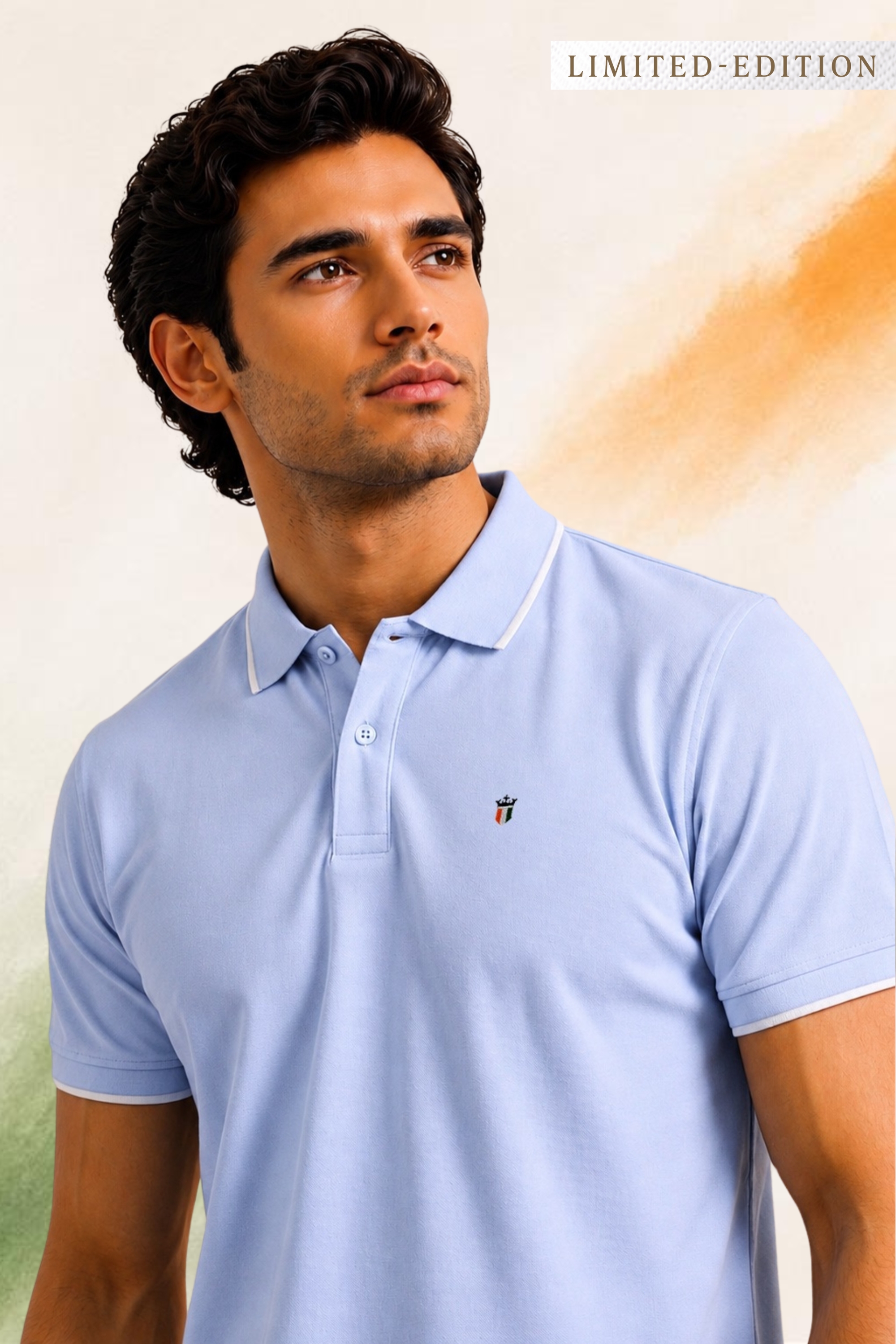 Man wearing a light blue polo shirt with a subtle emblem, posing against a soft beige and orange background. Limited edition text at top.
